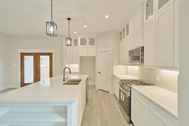 kitchen with sink, white cabinets, a center island with sink, and appliances with stainless steel finishes