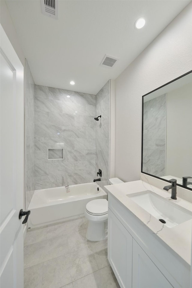 full bathroom featuring vanity, tile patterned floors, tiled shower / bath combo, and toilet