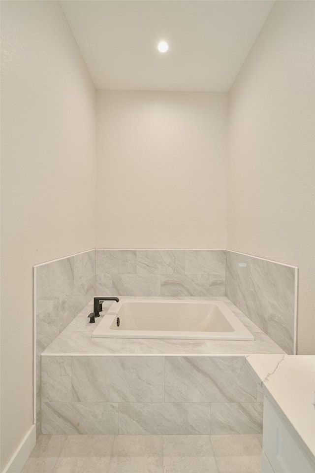 bathroom with vanity and a relaxing tiled tub