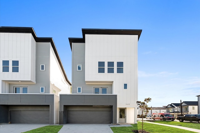 contemporary home featuring a front yard and a garage