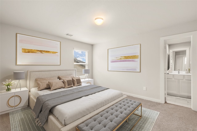 carpeted bedroom featuring sink and ensuite bath