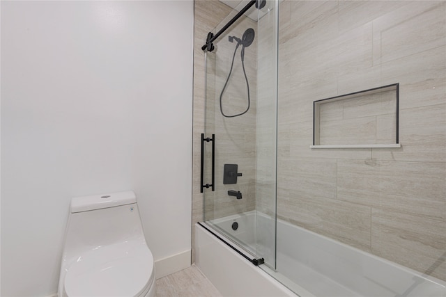 bathroom featuring bath / shower combo with glass door and toilet