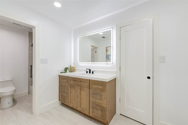 bathroom with vanity, wood-type flooring, and toilet