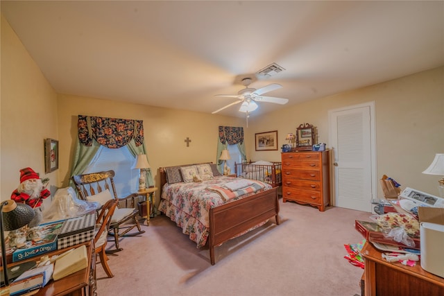 bedroom with ceiling fan, light colored carpet, and a closet