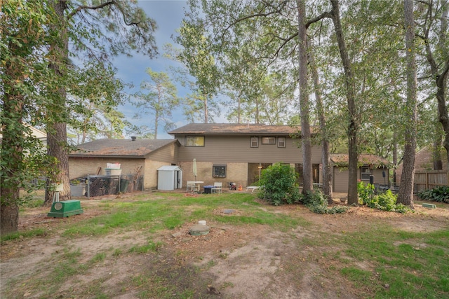 rear view of property with a storage shed