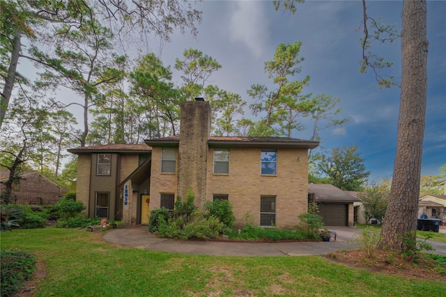 back of property featuring a yard and a garage