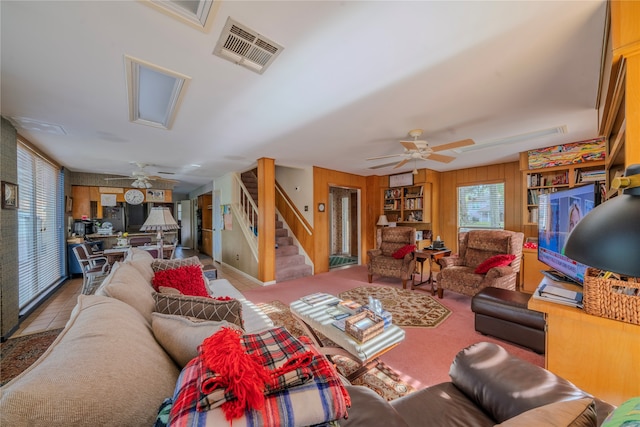 living room featuring wood walls and ceiling fan