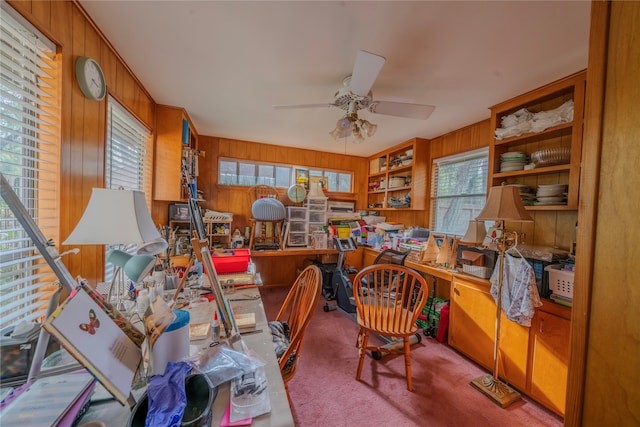 office area featuring carpet flooring, ceiling fan, and wood walls