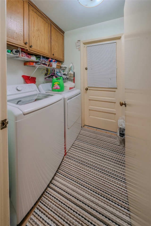 laundry area featuring washing machine and clothes dryer and cabinets