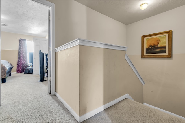 corridor with carpet and a textured ceiling