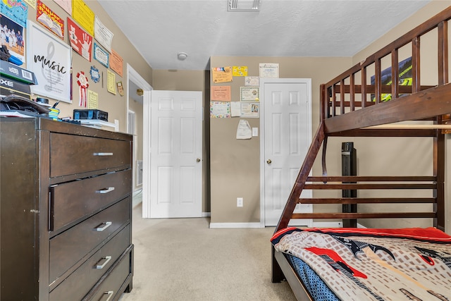 carpeted bedroom featuring a textured ceiling