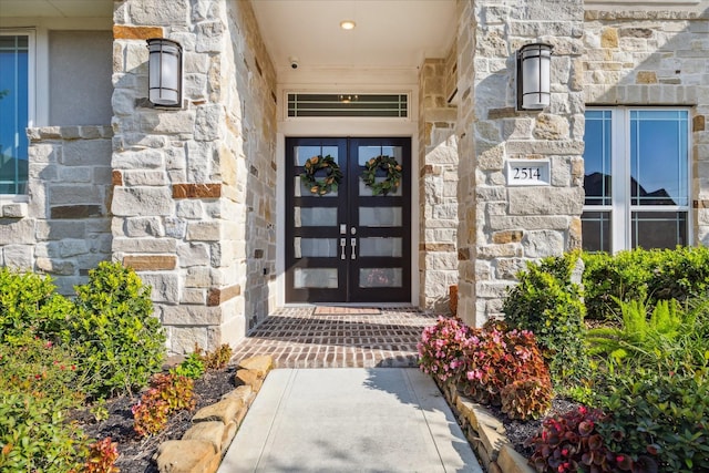 entrance to property featuring stone siding and french doors