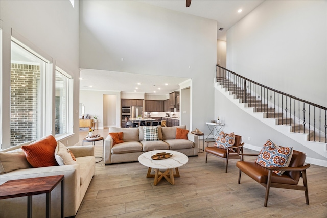 living room with a high ceiling and light wood-type flooring