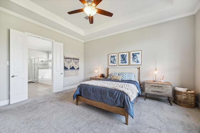 carpeted bedroom featuring ornamental molding, a tray ceiling, and baseboards