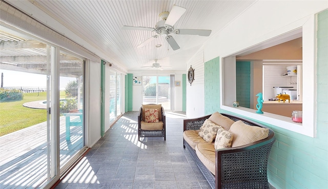 sunroom with ceiling fan and vaulted ceiling