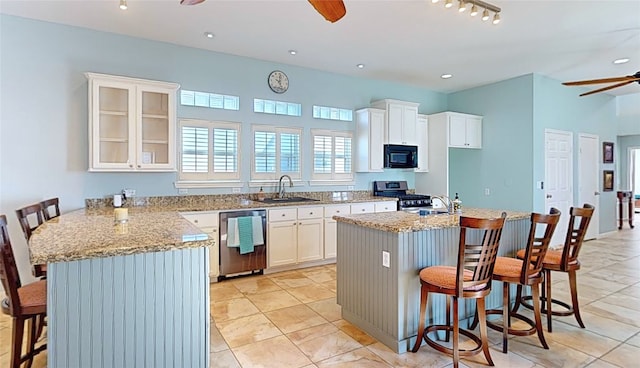 kitchen with appliances with stainless steel finishes, a center island, a breakfast bar area, and ceiling fan