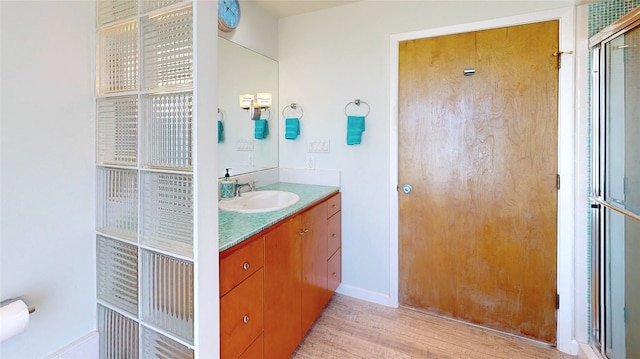 bathroom featuring vanity, an enclosed shower, and hardwood / wood-style floors