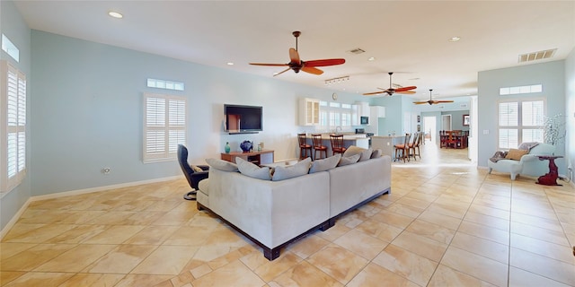 living room featuring light tile patterned flooring, plenty of natural light, and sink