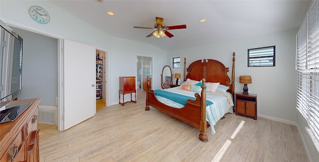 bedroom with ceiling fan, a walk in closet, light hardwood / wood-style floors, and a closet