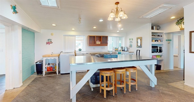 kitchen featuring crown molding, a breakfast bar, and decorative light fixtures