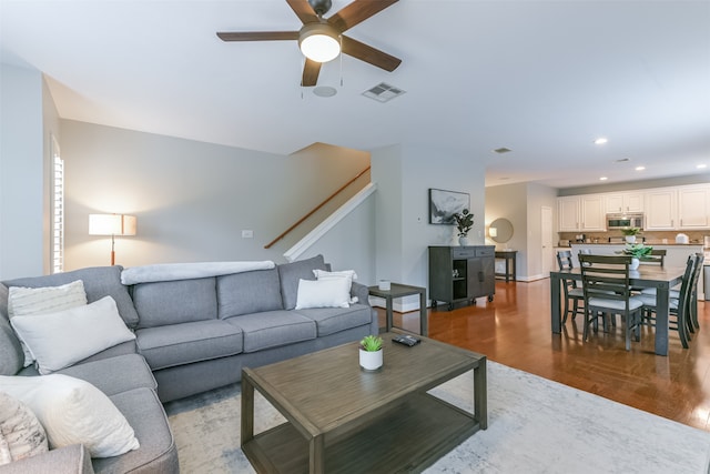 living room with ceiling fan and light hardwood / wood-style flooring