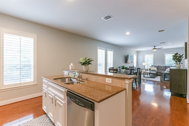 kitchen featuring dishwasher, white cabinets, a center island with sink, and light hardwood / wood-style flooring