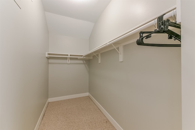 walk in closet featuring lofted ceiling and light carpet