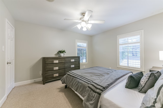 bedroom featuring light colored carpet, multiple windows, and ceiling fan