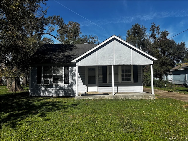 back of house with covered porch and a yard