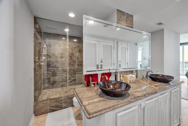 bathroom with tile patterned flooring, toilet, vanity, and walk in shower