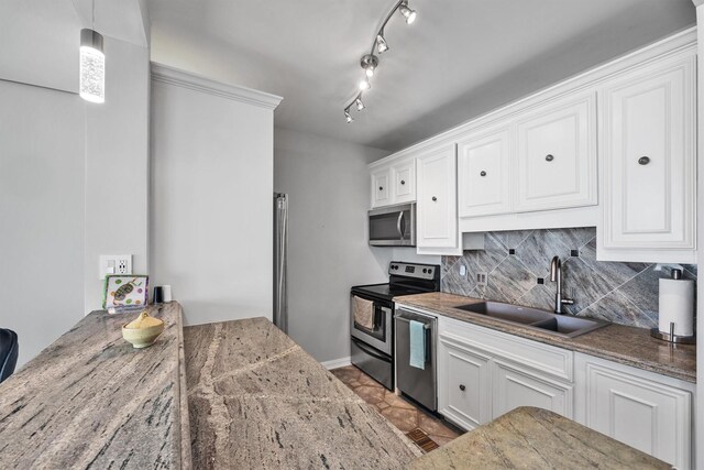 kitchen with appliances with stainless steel finishes, decorative light fixtures, sink, white cabinets, and decorative backsplash