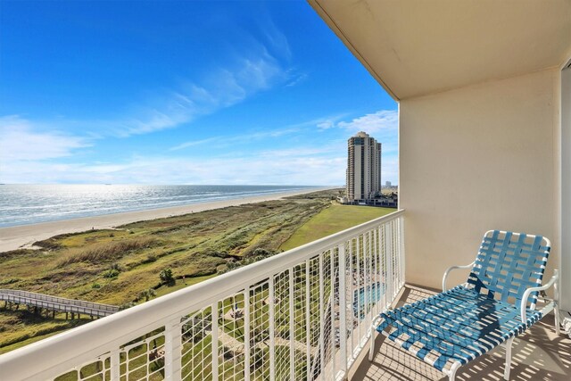 balcony featuring a water view and a view of the beach