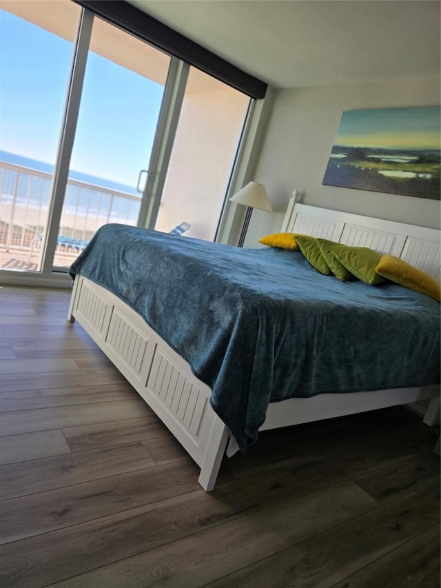 bedroom with multiple windows and dark wood-type flooring