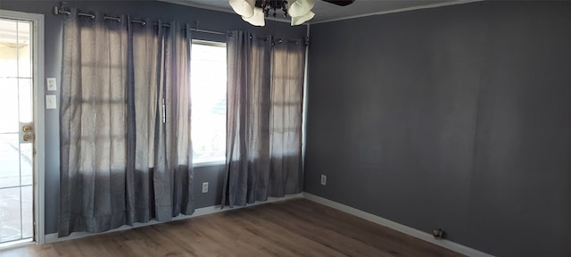 unfurnished room with a wealth of natural light, crown molding, and wood-type flooring