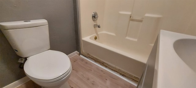 bathroom featuring hardwood / wood-style floors, toilet, and shower / bathtub combination