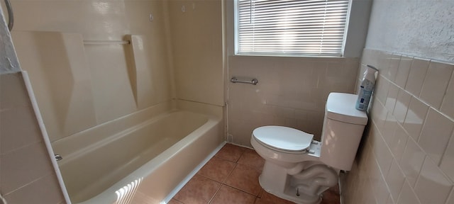 bathroom with shower / washtub combination, tile patterned flooring, tile walls, and toilet