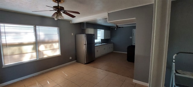 kitchen featuring stainless steel refrigerator, white cabinetry, ceiling fan, and a healthy amount of sunlight