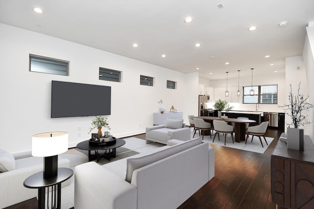 living room with dark hardwood / wood-style floors and sink