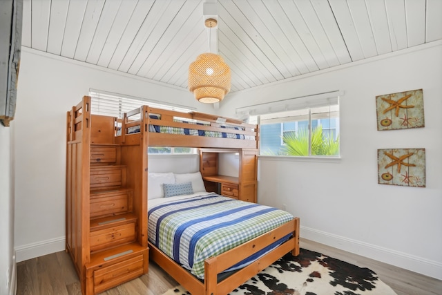 bedroom featuring light wood-type flooring, crown molding, and wood ceiling