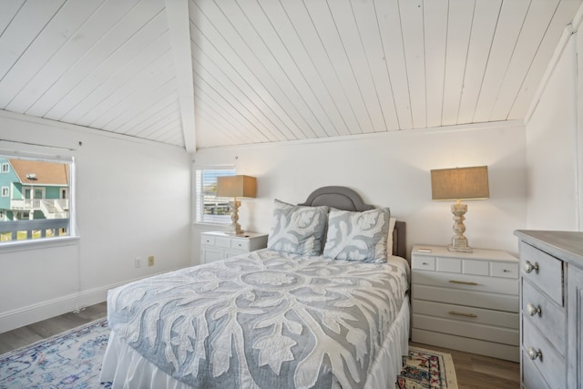 bedroom with multiple windows, light hardwood / wood-style floors, and vaulted ceiling