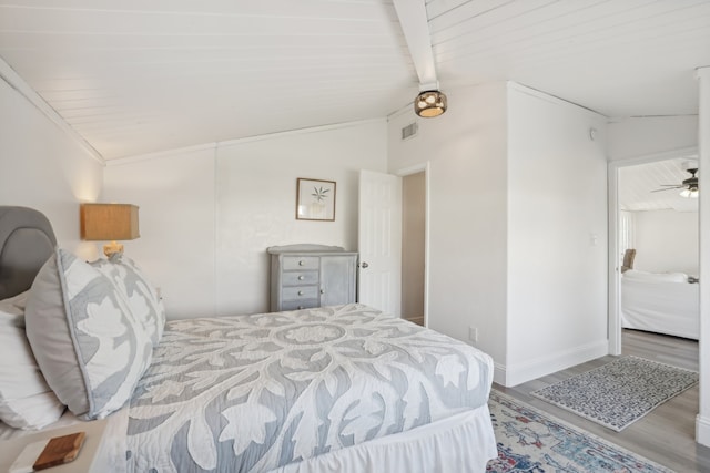 bedroom featuring lofted ceiling with beams and light hardwood / wood-style floors