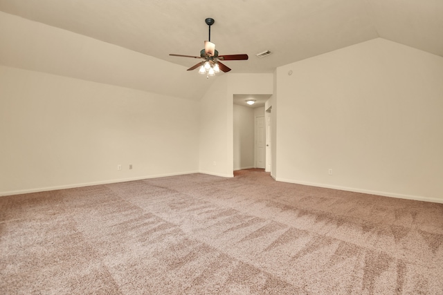 carpeted spare room featuring ceiling fan and vaulted ceiling