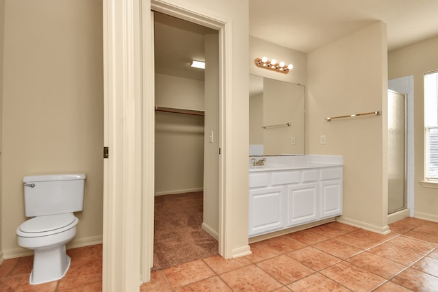 bathroom featuring toilet, vanity, tile patterned floors, and an enclosed shower