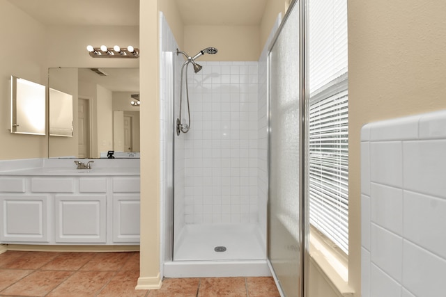 bathroom featuring tile patterned flooring, vanity, and walk in shower