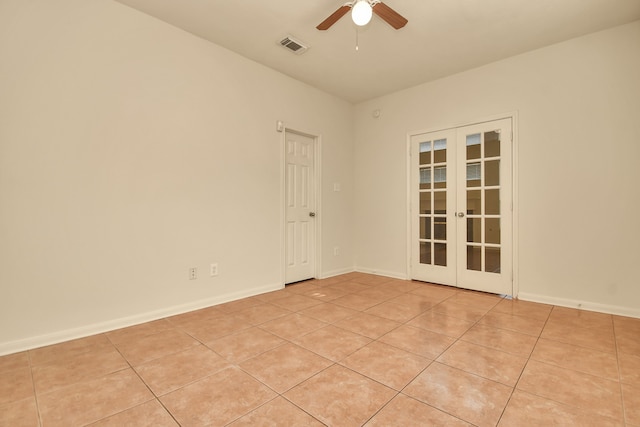 tiled empty room with ceiling fan and french doors