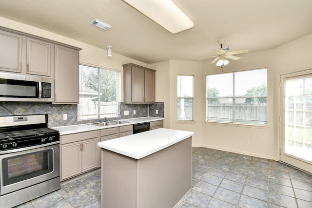 kitchen featuring a wealth of natural light, gray cabinets, decorative backsplash, and appliances with stainless steel finishes