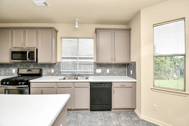 kitchen with tasteful backsplash, a healthy amount of sunlight, sink, and stainless steel appliances