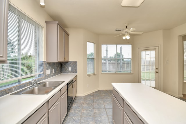 kitchen with gray cabinetry, ceiling fan, sink, black dishwasher, and backsplash