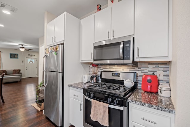 5907 Wedgefield St, Houston, TX 77028 - kitchen featuring appliances with stainless steel finishes, decorative backsplash, open floor plan, a ceiling fan, and dark wood finished floors
