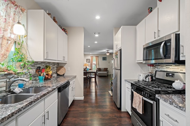 5907 Wedgefield St, Houston, TX 77028 - kitchen with appliances with stainless steel finishes, a sink, dark wood-style floors, tasteful backsplash, and recessed lighting